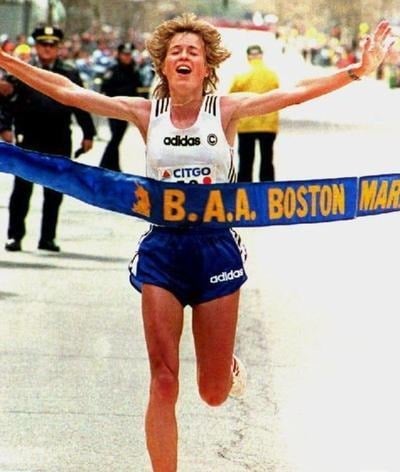 Uta Pippig throwing her arms up as she breaks the tape at the Boston Marathon